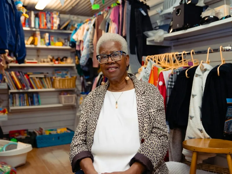 A shop owner standing behind the counter in her store.
